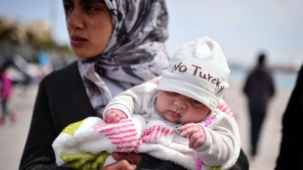 A Syrian refugee holds a two-month old baby as refugees and migrants who broke out from Chios detention camp, and camped out in the port of the city, stage a protest with their children chanting 'No Turkey' on April 3, 2016. A Syrian refugee holds a two-month old baby as refugees and migrants who broke out from Chios detention camp, and camped out in the port of the city, stage a protest with their children chanting 'No Turkey' on April 3, 2016. - Sputnik International