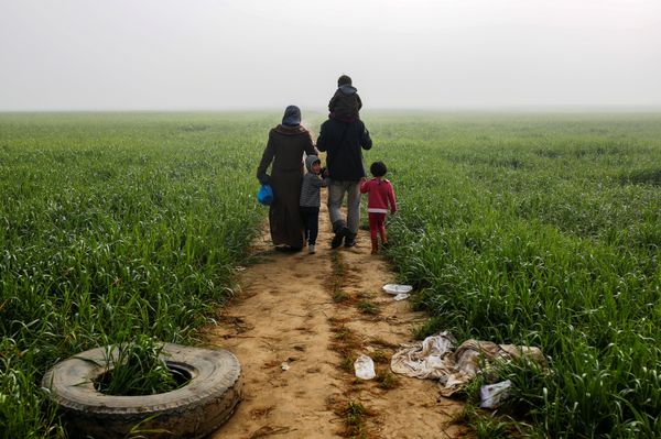 A family walks through a field at a makeshift camp for migrants and refugees at the Greek-Macedonian border near the village of Idomeni, Greece, April 4, 2016. - Sputnik International