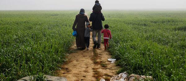 A family walks through a field at a makeshift camp for migrants and refugees at the Greek-Macedonian border near the village of Idomeni, Greece, April 4, 2016. - Sputnik International
