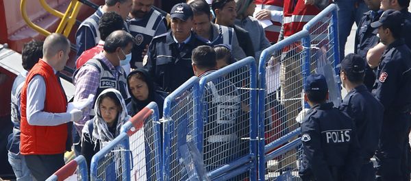 Migrants are escorted by Turkish police officers as they arrive in the Turkish coastal town of Dikili, Turkey, April 4, 2016. - Sputnik International
