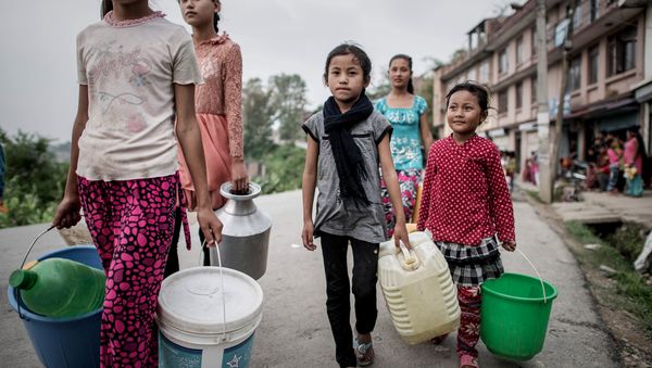 Children carry buckets to get water distributed as relief aid outside Bungamati village, in the outskirts of Kathmandu on May 8, 2015. Children carry buckets to get water distributed as relief aid outside Bungamati village, in the outskirts of Kathmandu on May 8, 2015. - Sputnik International