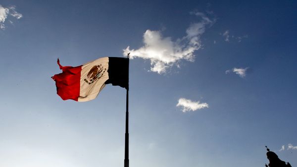 A Mexican flag flutters at the Zocalo square in Mexico City, on April 29, 2009. The World Health Organisation raised its flu alert to phase five out of six, WHO chief Margaret Chan said, signalling that a pandemic was imminent following the swine flu outbreak. - Sputnik International