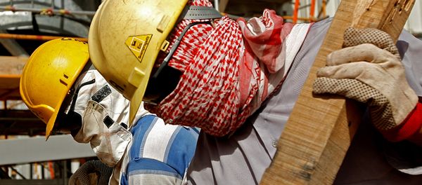 Foreign workers, covering their faces from dust and the blazing sun, work inside the Khouris central processiong oil facility that is still under construction in Saudi Arabia's desert, 160 kms east of the capital Riyadh (File) - Sputnik International