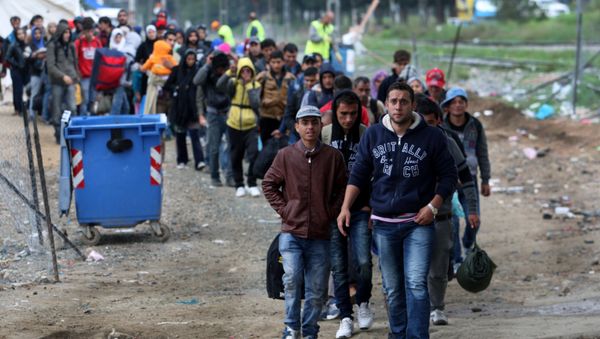Migrants and refugees walk to cross Greek-Macedonian border near the village of Idomeni, in northern Greece on October 14, 2015 - Sputnik International