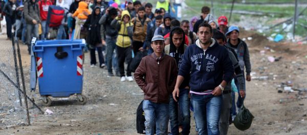 Migrants and refugees walk to cross Greek-Macedonian border near the village of Idomeni, in northern Greece on October 14, 2015 - Sputnik International