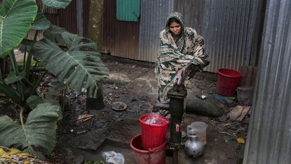 In this April 5, 2016 photo, a Bangladeshi woman collects arsenic-tainted water from a tube-well in Khirdasdi village, outskirts of Dhaka, Bangladesh In this April 5, 2016 photo, a Bangladeshi woman collects arsenic-tainted water from a tube-well in Khirdasdi village, outskirts of Dhaka, Bangladesh - Sputnik International