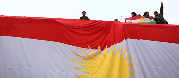 Iraqi Kurdish youths wave a national flag as they stand above a giant flag of Kurdistan during celebrations of Flag Day on December 17, 2015 Iraqi Kurdish youths wave a national flag as they stand above a giant flag of Kurdistan during celebrations of Flag Day on December 17, 2015 - Sputnik International