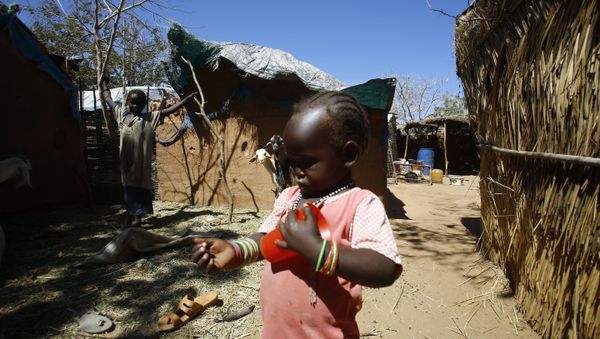A Sudanese girl walks between huts at the Abuzar camp near West Darfur state capital Geneina on February 2, 2016 - Sputnik International