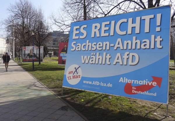 A man walks past a campaign poster of right-populist AfD party reading It's enough - Saxony-Anhalt elects AfD in Magdeburg, Germany. - Sputnik International