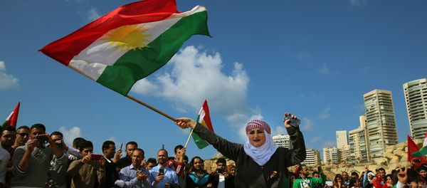 Syrian Kurd Nazdan who fled her home in Qamishli, Syria, wears traditional clothes as she dances and waves a Kurdish flag, during a celebration of Nowruz day, in Beirut, Lebanon, Monday, March 21, 2016 - Sputnik International