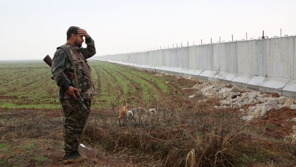 A Kurdish People's Protection Unit(YPG) fighter stands near a wall which activists say was put up by Turkish authorities, on the Syria-Turkey border in the western Syrian countryside of Ras al-Ain on February 2, 2016 A Kurdish People's Protection Unit(YPG) fighter stands near a wall which activists say was put up by Turkish authorities, on the Syria-Turkey border in the western Syrian countryside of Ras al-Ain on February 2, 2016 - Sputnik International