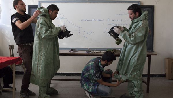 Aleppo University student, shows Syrian citizens hows to put protective gear as he instructs them with rudimentary means of how to respond to a chemical attack, in the northern Syrian city of Aleppo (File) Aleppo University student, shows Syrian citizens hows to put protective gear as he instructs them with rudimentary means of how to respond to a chemical attack, in the northern Syrian city of Aleppo (File) - Sputnik International