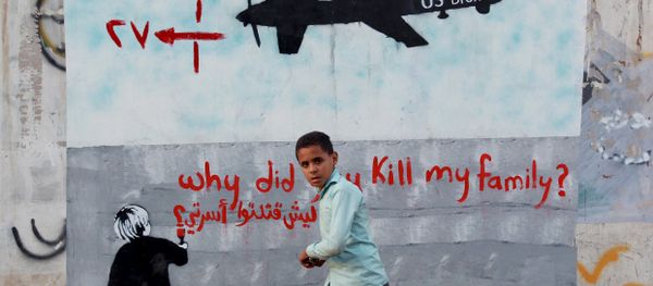 A Yemeni boy (C) walks past a mural depicting a US drone and reading  Why did you kill my family on December 13, 2013 in the capital Sanaa. - Sputnik International