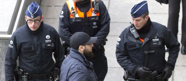 Accused Bilal El Makhoukhi, center front, speaks with police outside the main courthouse in Antwerp, Belgium - Sputnik International