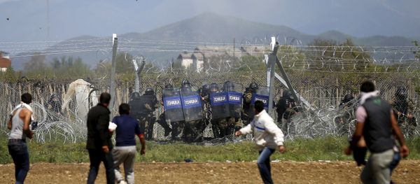 Migrants throw stones at Macedonian police during clashes next to a border fence at a makeshift camp at the Greek-Macedonian border near the village of Idomeni, Greece - Sputnik International