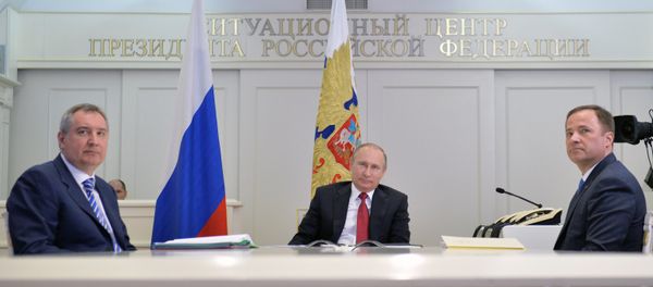 Russian President Vladimir Putin, center, Deputy Prime Minister Dmitry Rogozin, left, and Igor Komarov, General Director of the Roscosmos State Corporation for Space Activities, take part in a videoconference with the International Space Station and the Vostochny space center at the situation center in the Kremlin. - Sputnik International
