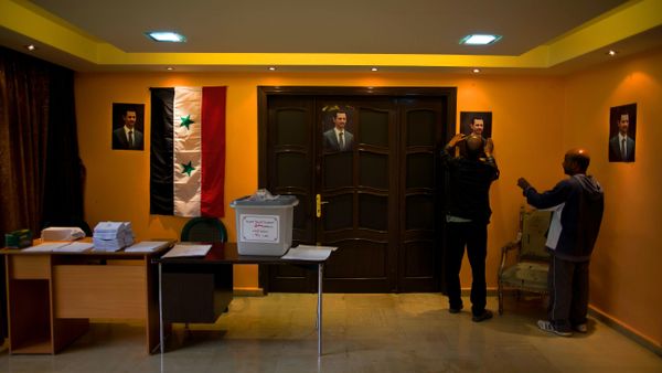 An empty ballot box with Arabic that reads, Syrian Arab Republic, Damascus Governorate, Election ballot box, number 210, is seen at a polling station as workers hang portraits of Syrian President Bashar Assad in Damascus, Syria, Tuesday, April 12, 2016. - Sputnik International