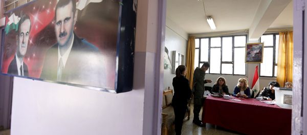 A banner showing Syria's president Bashar al-Assad and his father, former president Hafez al-Assad is seen inside a polling station during the parliamentary elections in Damascus, Syria - Sputnik International