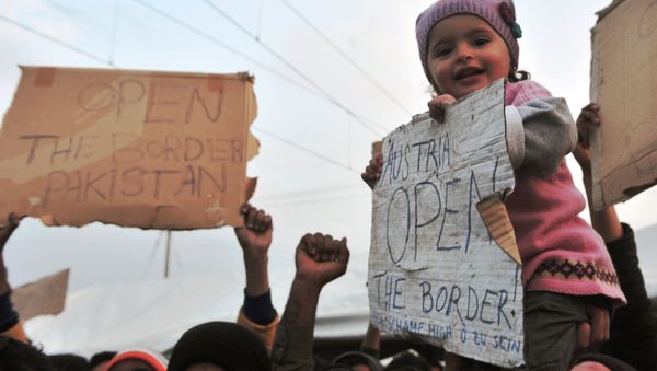 A child is carried as she holds a banner reading Austria open the border! during a demonstration at the makeshift camp at the Greek-Macedonian border, near the Greek village of Idomeni on March 26, 2016. A child is carried as she holds a banner reading Austria open the border! during a demonstration at the makeshift camp at the Greek-Macedonian border, near the Greek village of Idomeni on March 26, 2016. - Sputnik International