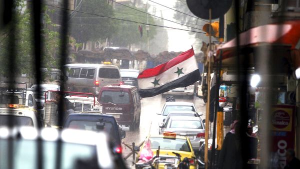 Vehicles travel on a busy road near a Syrian national flag in Qamishli, Syria April 11, 2016. Vehicles travel on a busy road near a Syrian national flag in Qamishli, Syria April 11, 2016. - Sputnik International