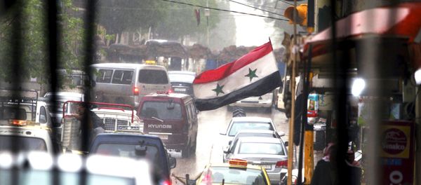 Vehicles travel on a busy road near a Syrian national flag in Qamishli, Syria April 11, 2016. Vehicles travel on a busy road near a Syrian national flag in Qamishli, Syria April 11, 2016. - Sputnik International