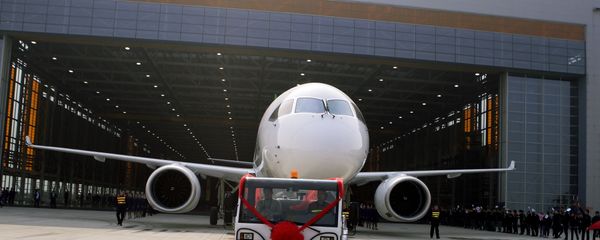 Chinese workers wave flags as a truck pulls out the first twin-engine 158-seater C919 passenger plane made by The Commercial Aircraft Corp. of China (COMAC) during a ceremony at the company's hangar near the Pudong International Airport in Shanghai, China. (File) Chinese workers wave flags as a truck pulls out the first twin-engine 158-seater C919 passenger plane made by The Commercial Aircraft Corp. of China (COMAC) during a ceremony at the company's hangar near the Pudong International Airport in Shanghai, China. (File) - Sputnik International