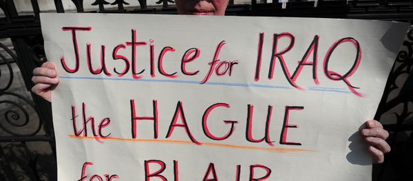 An anti-war protester holds a placard that reads Justice for Iraq, the Hague for Blair during a demonstration outside the High Court in central London on May 28, 2012. - Sputnik International