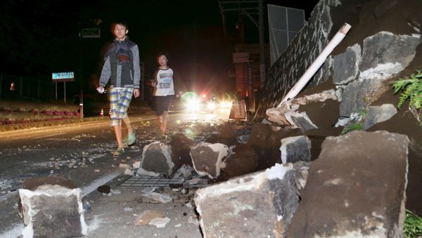 Local residents walk next to a collapsed wall after an earthquake in Mashiki town, Kumamoto prefecture, southern Japan, in this photo taken by Kyodo April 14, 2016 Local residents walk next to a collapsed wall after an earthquake in Mashiki town, Kumamoto prefecture, southern Japan, in this photo taken by Kyodo April 14, 2016 - Sputnik International