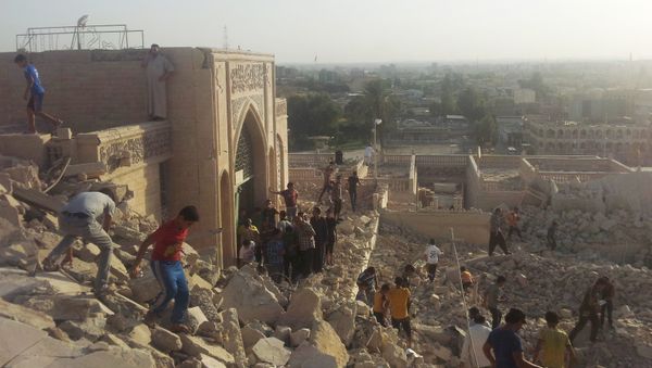 People walk on the rubble of the destroyed Mosque of The Prophet Younis, or Jonah, in Mosul, 225 miles (360 kilometers) northwest of Baghdad, Iraq (File) - Sputnik International