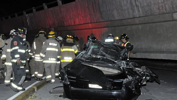 Rescue workers stand before a destroyed car after the collapse of a bridge in an earthquake, April 16, 2016 in Guayaquil, Ecuador - Sputnik International