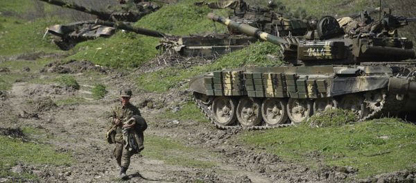 A soldier of the defense army of Nagorny Karabakh walks past tanks at a field position outside the village of Mataghis, some 70km north of Karabakh's capital Stepanakert, on April 6, 2016 A soldier of the defense army of Nagorny Karabakh walks past tanks at a field position outside the village of Mataghis, some 70km north of Karabakh's capital Stepanakert, on April 6, 2016 - Sputnik International