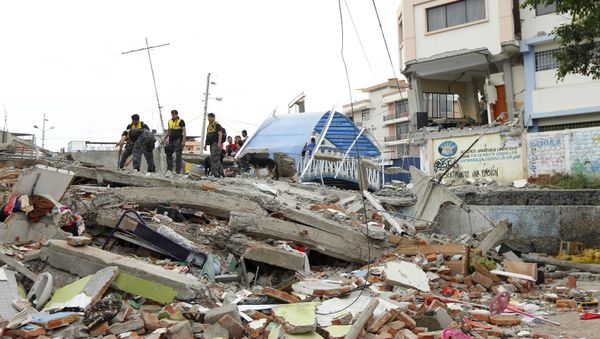 Police officers stand on debris after an earthquake struck off Ecuador's Pacific coast, at Tarqui neighborhood in Manta April 17, 2016 - Sputnik International