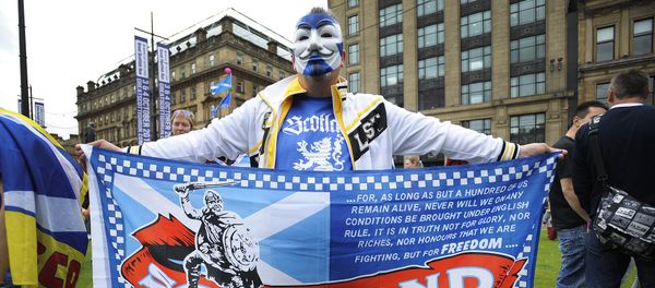 A pro Independence supporter wearing a Guy Fawkes mask bearing St Andrew's Cross holds a flag during a rally in George Square in Glasgow, Scotland (File) A pro Independence supporter wearing a Guy Fawkes mask bearing St Andrew's Cross holds a flag during a rally in George Square in Glasgow, Scotland (File) - Sputnik International