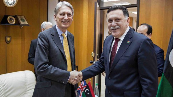In this photo provided by the Libyan Government of National Accord, Libyan prime minister-designate Fayez Serraj , right and British Foreign Secretary Philip Hammond shake hands for photographers in Tripoli, Libya, Monday, April 18, 2016. In this photo provided by the Libyan Government of National Accord, Libyan prime minister-designate Fayez Serraj , right and British Foreign Secretary Philip Hammond shake hands for photographers in Tripoli, Libya, Monday, April 18, 2016. - Sputnik International
