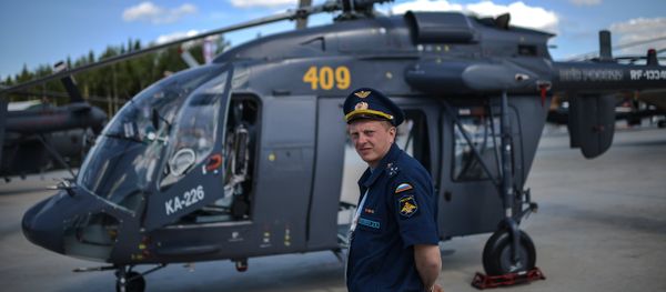 A pilot stands next to a Ka-226 helicopter at the ARMY-2015 international military technical forum held outside Moscow. - Sputnik International