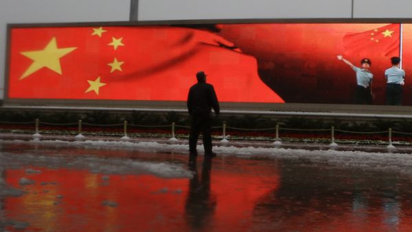 Chinese man stands near a screen displaying the Chinese national flag (File) Chinese man stands near a screen displaying the Chinese national flag (File) - Sputnik International