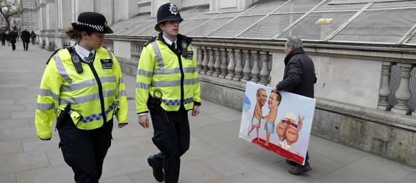 Political artist Kaya Mar (R) holds a painting as walks near 10 Downing Street in central London on April 22, 2016 Political artist Kaya Mar (R) holds a painting as walks near 10 Downing Street in central London on April 22, 2016 - Sputnik International