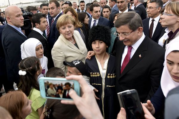 Turkish Prime Minister Ahmet Davutoglu and German Chancellor Angela Merkel pose for a picture with refugees in Nizip refugee camp near Gaziantep, Turkey, April 23, 2016 - Sputnik International