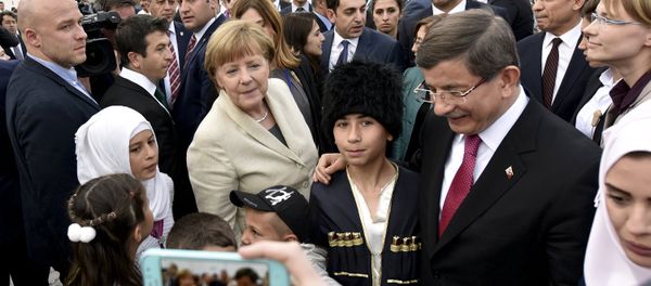 Turkish Prime Minister Ahmet Davutoglu and German Chancellor Angela Merkel pose for a picture with refugees in Nizip refugee camp near Gaziantep, Turkey, April 23, 2016 - Sputnik International