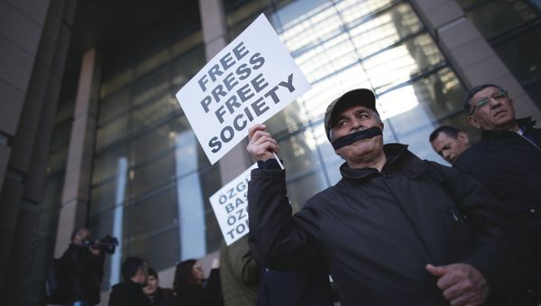Turkish journalists cover their mouths with black ribbons before the trial of Can Dundar, the editor-in-chief of opposition newspaper Cumhuriyet and Erdem Gul, the paper's Ankara representative, outside the courthouse in Istanbul, Friday, April 1, 2016 - Sputnik International