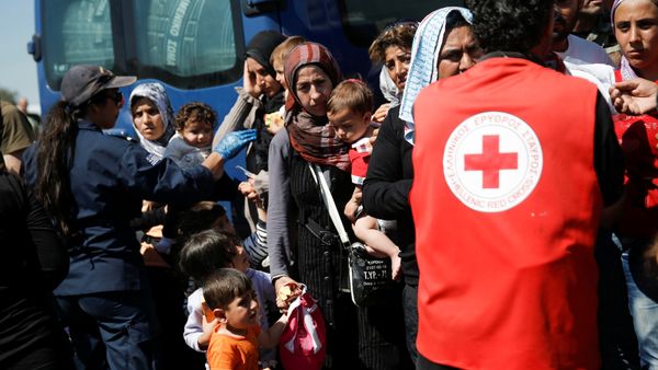 A woman holds two children as refugees and migrants wait to board a bus that will transfer them from a makeshift camp at the port of Piraeus to a newly built relocation centre in the port town of Skaramagkas, in western Athens, Greece April 18, 2016 - Sputnik International
