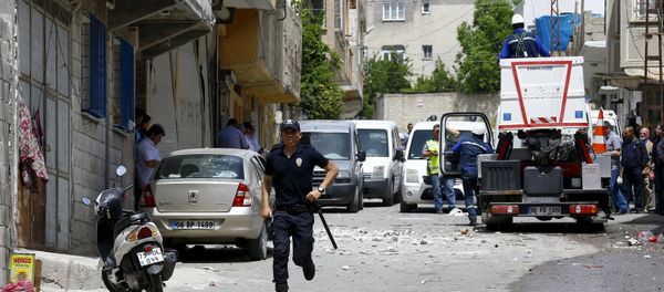 A riot police officer runs away from the site after two rockets hit the Turkish town of Kilis near the Syrian border, Turkey, April 24, 2016 - Sputnik International