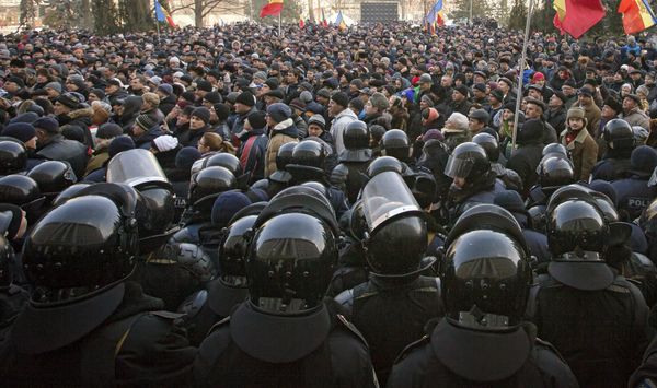 Riot police officers stand in line in front of protesters, some wanting closer links to Russia, others demanding a crackdown on corruption, outside the parliament in Chisinau, Moldova, Thursday, Jan. 21, 2016. The country has faced regular protests since early 2015. - Sputnik International