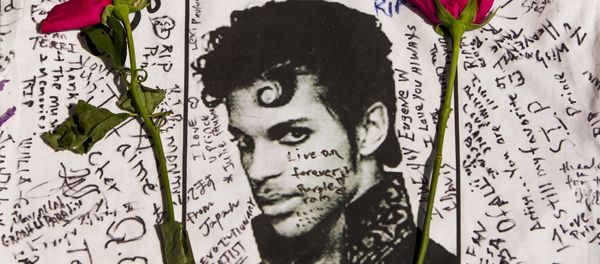 Flowers lay on a T-shirt signed by fans of singer Prince at a makeshift memorial place created outside Apollo Theater in New York. Flowers lay on a T-shirt signed by fans of singer Prince at a makeshift memorial place created outside Apollo Theater in New York. - Sputnik International