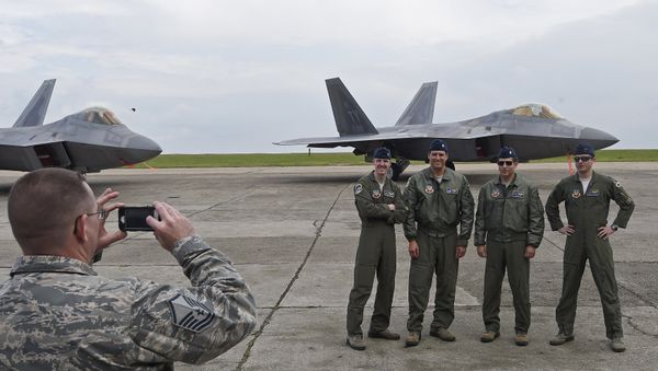US pilots pose for a photograph in front of US F-22 Raptor fighters parked on the runway at Mihail Kogalniceanu air base in Romania April 25, 2016. - Sputnik International
