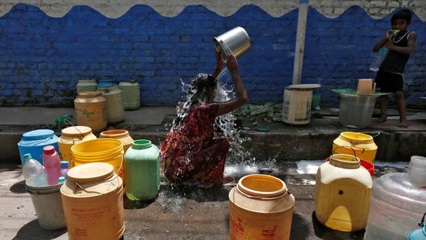 A woman bathes at a roadside municipal tap in a slum area on a hot summer day, India, April 22, 2016. A woman bathes at a roadside municipal tap in a slum area on a hot summer day, India, April 22, 2016. - Sputnik International