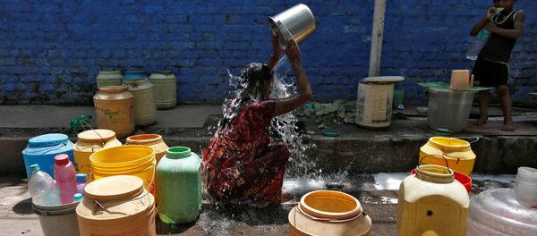 A woman bathes at a roadside municipal tap in a slum area on a hot summer day, India, April 22, 2016. A woman bathes at a roadside municipal tap in a slum area on a hot summer day, India, April 22, 2016. - Sputnik International