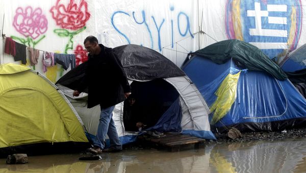 A refugee walks next to tents following heavy rainfall at a makeshift camp for migrants and refugees at the Greek-Macedonian border near the village of Idomeni, Greece, April 24, 2016. - Sputnik International