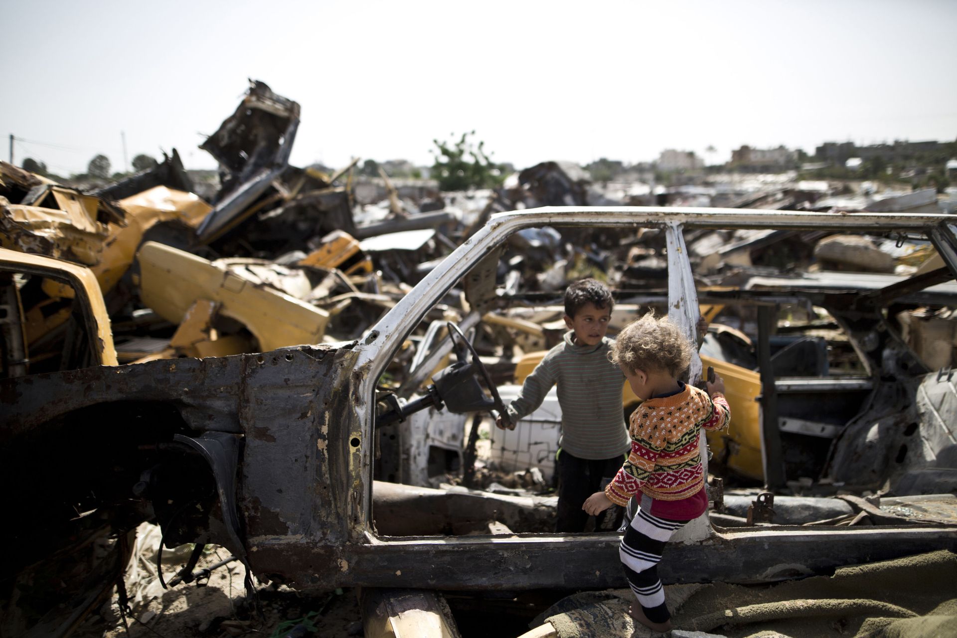 Palestinian children play in abandoned vehicles in an impoverished area in the southern Gaza Strip city of Khan Yunis, on April 26, 2016.  - Sputnik International, 1920, 31.05.2022