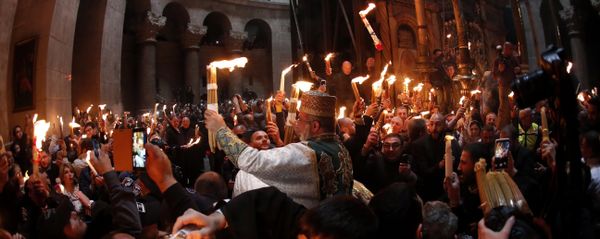 Christian Orthodox worshipers hold up candles lit from the Holy Fire as thousands gather in the Church of the Holy Sepulchre in Jerusalem’s Old City (File) - Sputnik International